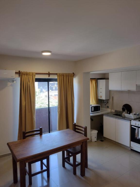 cocina con mesa de madera y sillas en una habitación en Departamento 2 ambientes céntrico en Tucumán en San Miguel de Tucumán