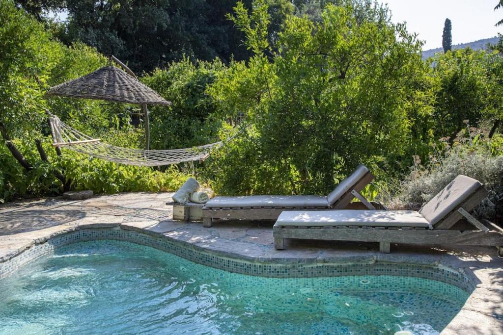 - une piscine avec 2 chaises longues et un hamac à côté de la piscine dans l'établissement Cozy House with Garden in Bodrum Bitez, à Bitez