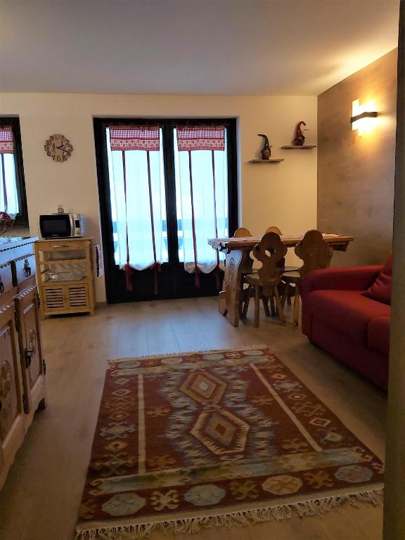 a living room with a red couch and a table at La petite maison in La Thuile