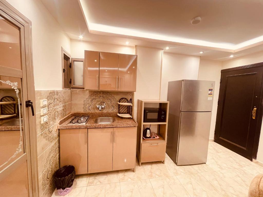 a kitchen with a refrigerator and a sink at El mansour hotel apartmen 72 in Mansoura