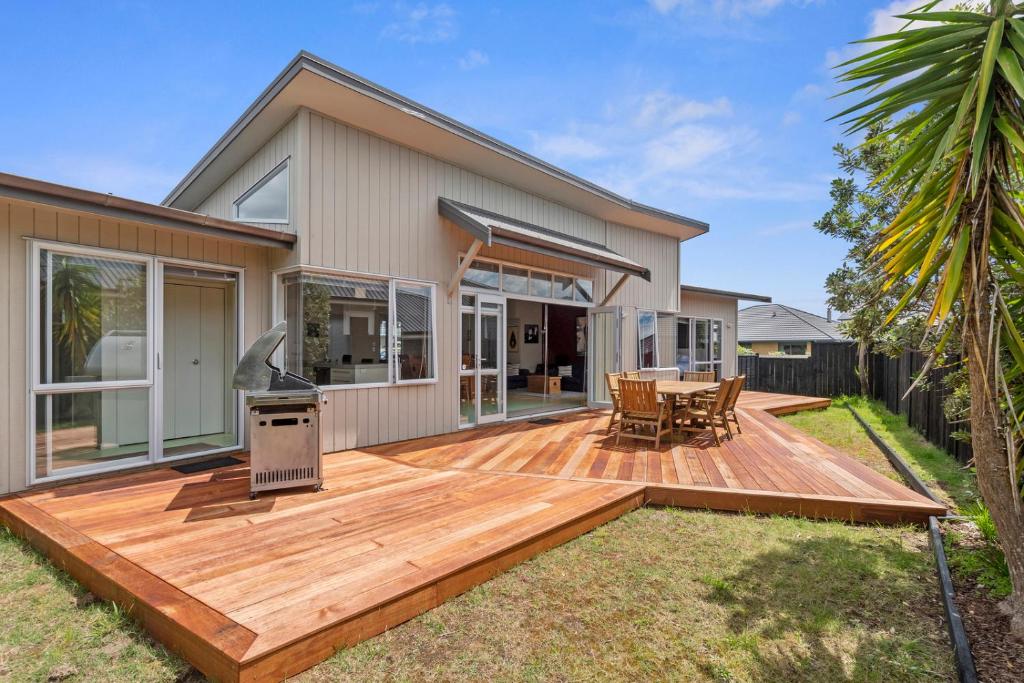 a wooden deck in front of a house at Restful Ruakaka - Ruakaka Holiday Home in Ruakaka