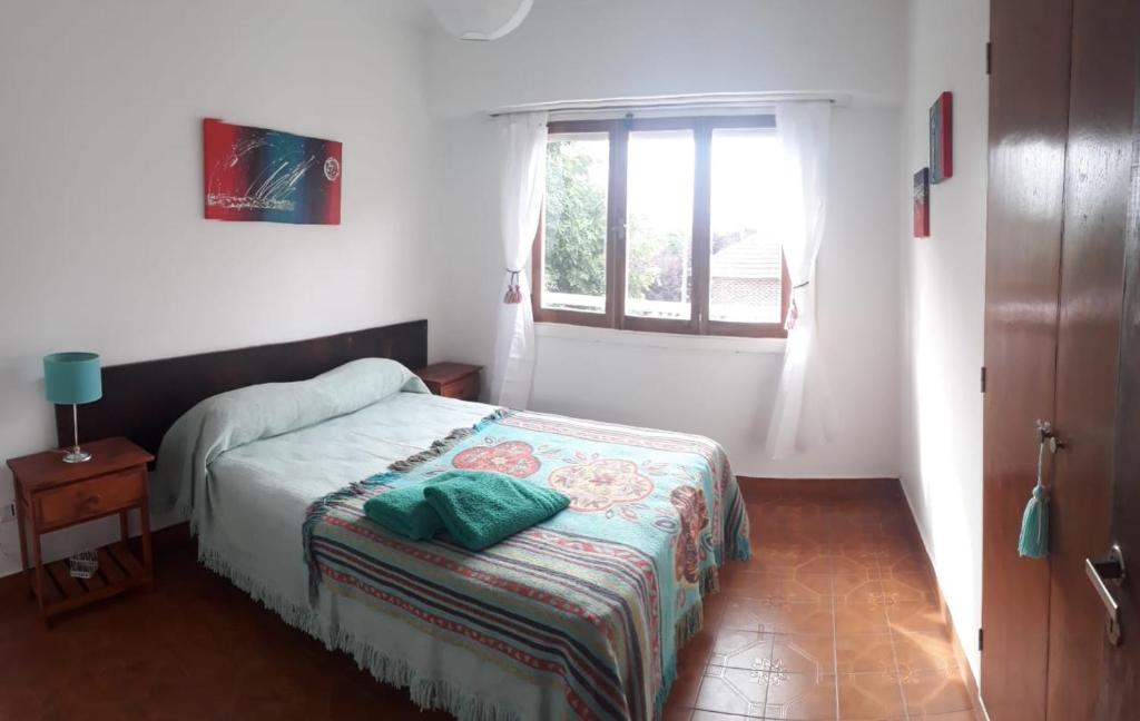 Habitación pequeña con cama y ventana en Departamento temporal Necochea en Necochea