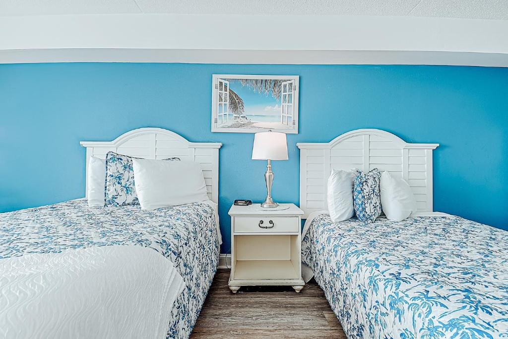 2 camas en un dormitorio con paredes azules en Ocean front comfy condo w/kitchen, sleeps 4, Snowbird Paradise en Myrtle Beach