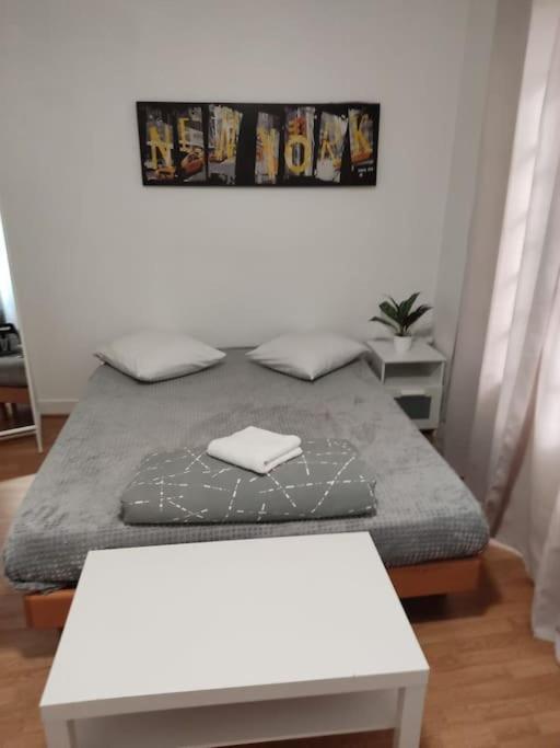 - une chambre avec un lit et une table blanche dans l'établissement Studio Paris 13, à Paris