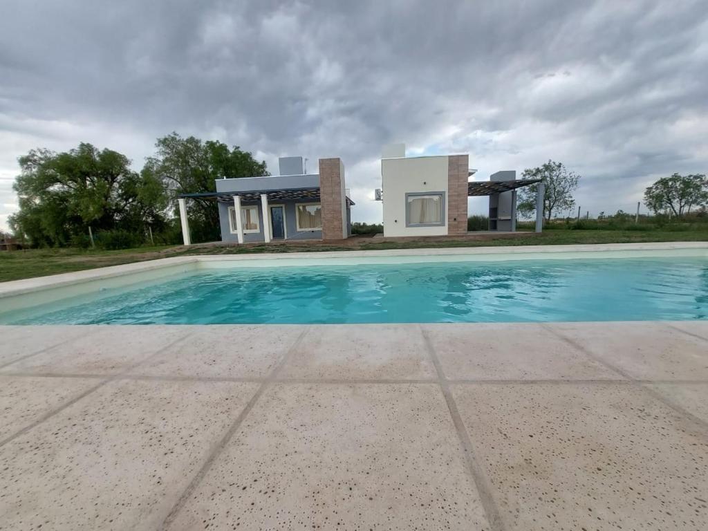 Villa con piscina frente a una casa en Complejo Blend en San Rafael