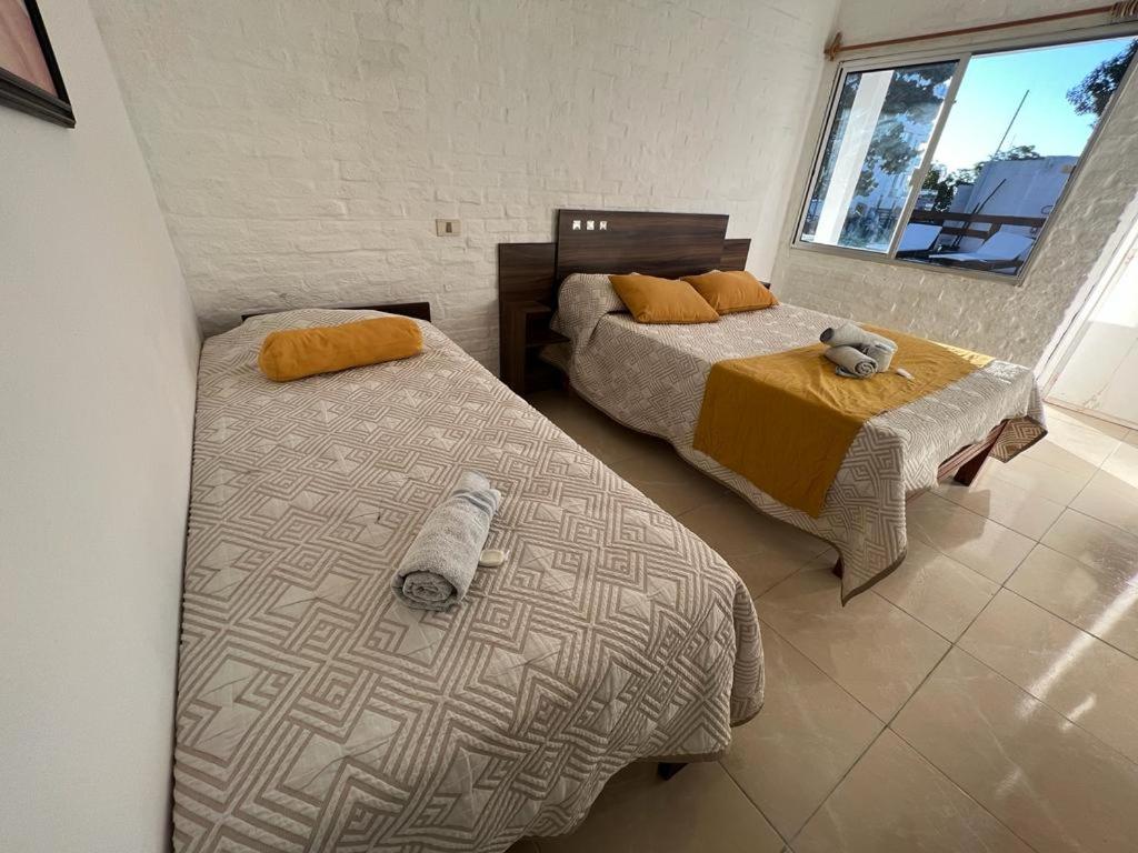 a bedroom with two beds and a window at Gran Colonial Riviera in Piriápolis