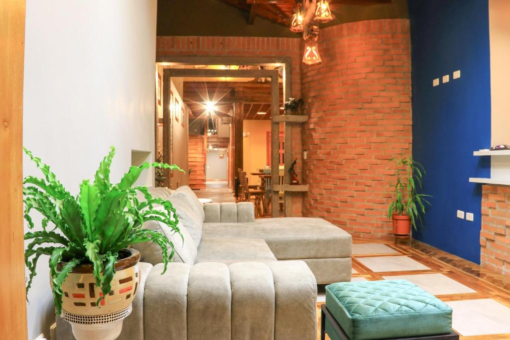 Hotel Entre Brumas في Aguadas: غرفة معيشة مع أريكة وجدار من الطوب