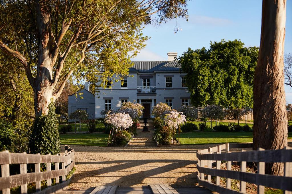 een wit huis met een hek ervoor bij Prospect Country House & Restaurant in Richmond