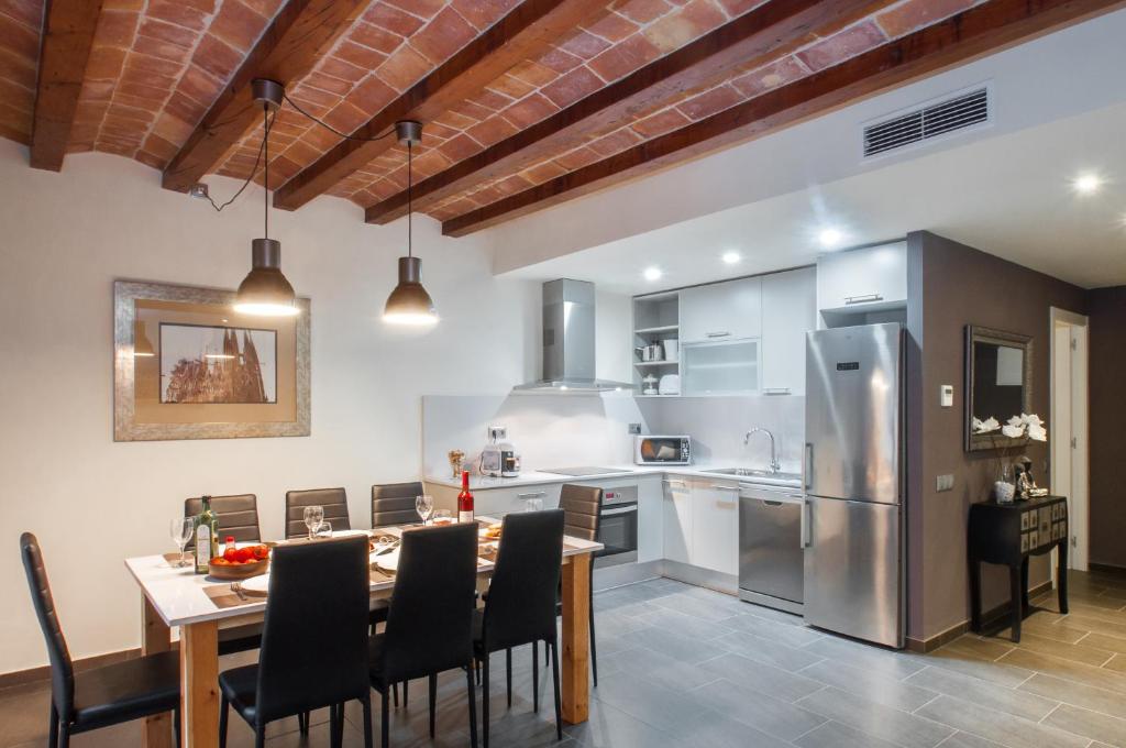 a kitchen with a table and chairs and a refrigerator at Autèntic Eixample Barcelona in Barcelona