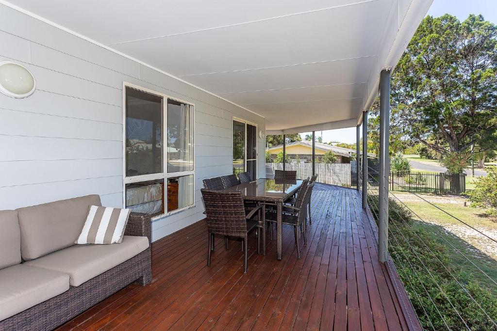 a porch with a couch and a table and chairs at Rainbow Tides in Rainbow Beach