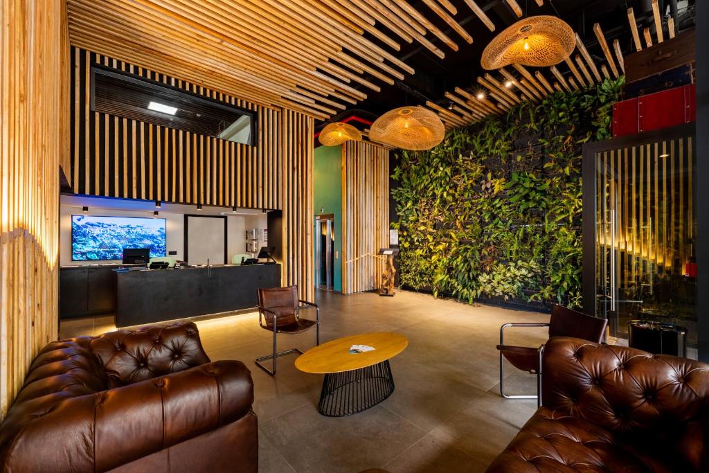 una hall con mobili in pelle e una grande parete verde di Boutique Hôtel Kon Tiki Tahiti a Papeete