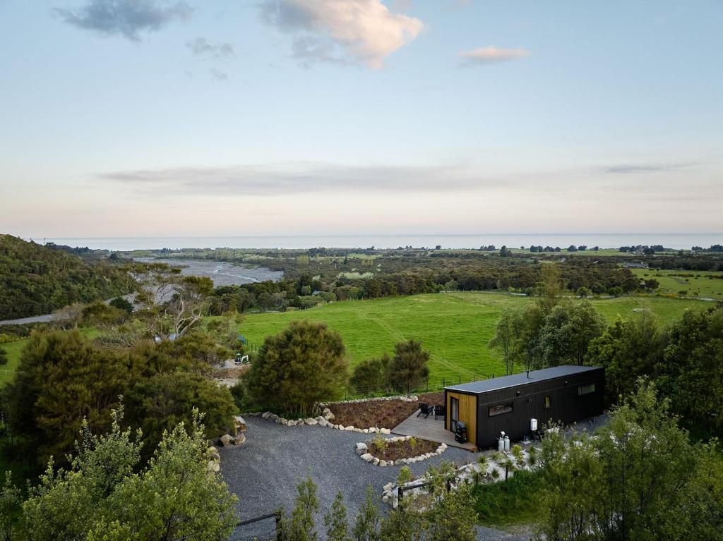 an aerial view of a black house in a field at Hapuku River Terrace a Eco Tiny House escape in Kaikoura