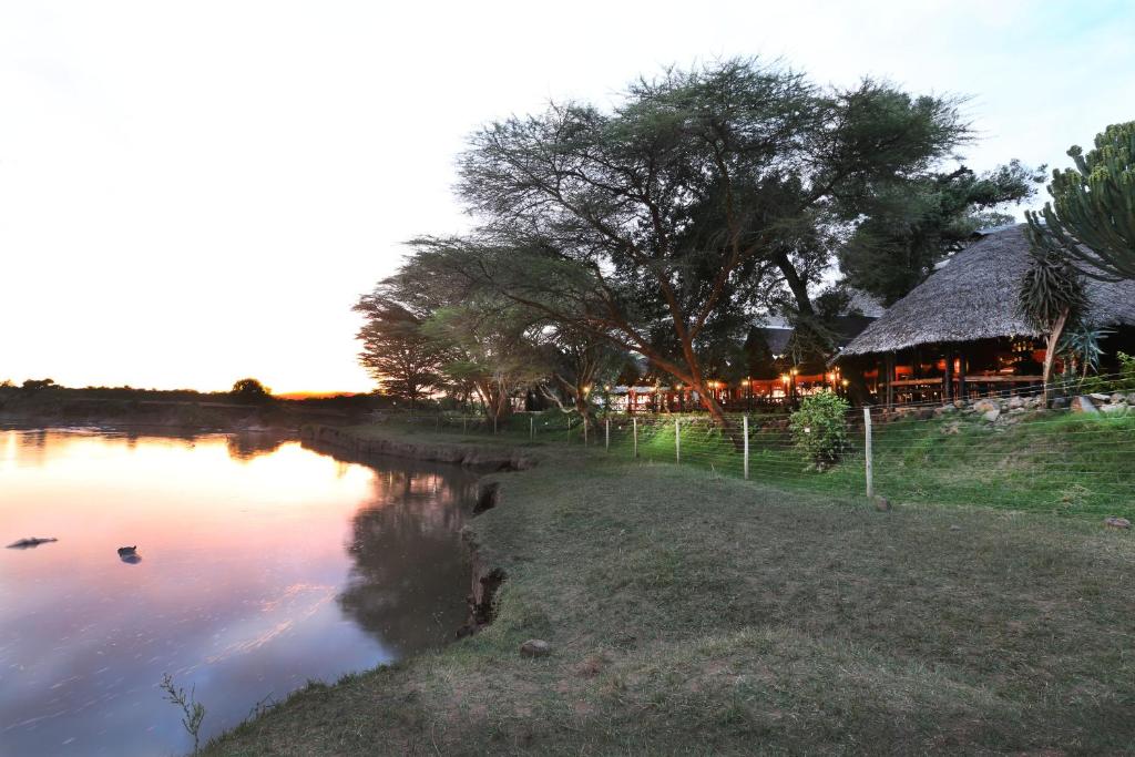 a view of a river with a hut in the background at Mara River Lodge in Aitong