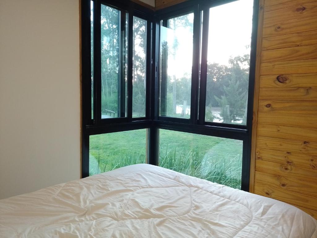 a bedroom with a bed and a large window at Muelle Delta Arias - EN TIGRE ISLA - in Tigre