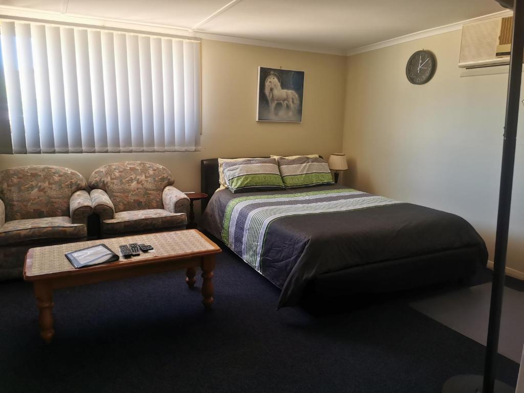 a bedroom with a bed and a couch at Chrissie's Dongara in Kimba