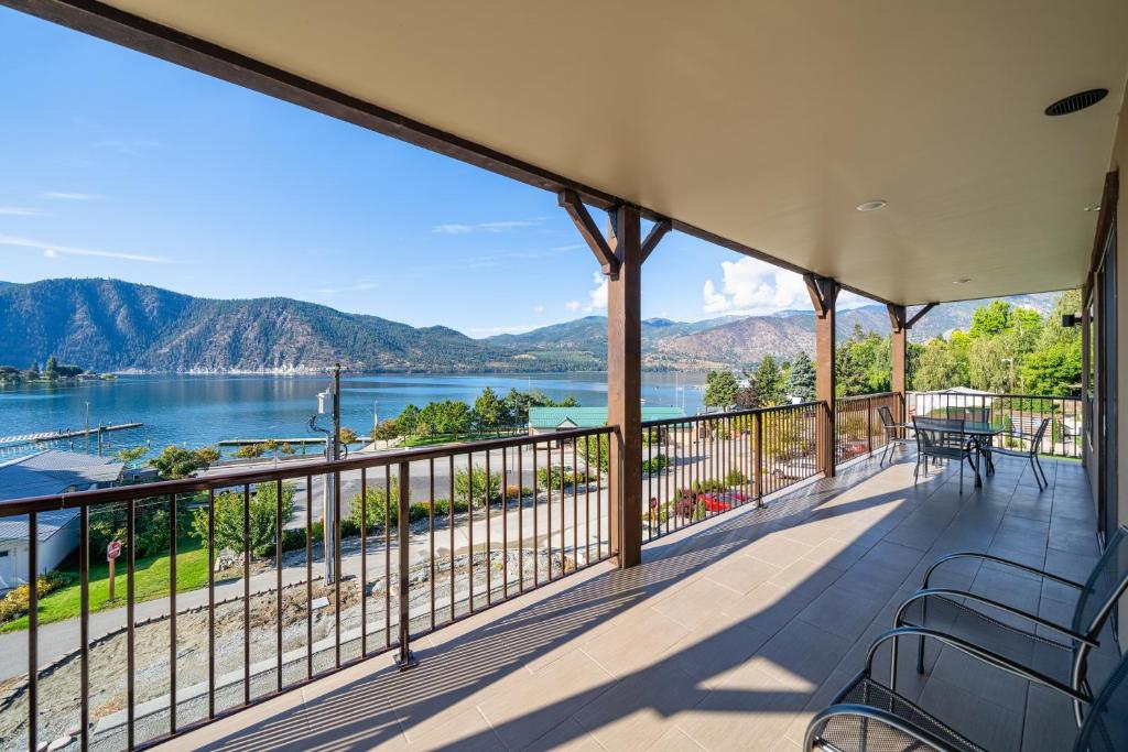 a balcony with a view of the water and mountains at Marina's Edge Condo walk to restaurants and wineries condo in Manson