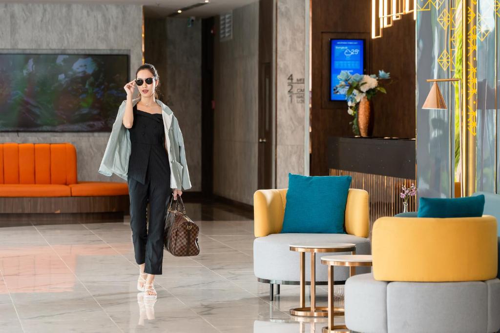 A polished lobby combines a reception desk with colorful lounge seating and large windows.