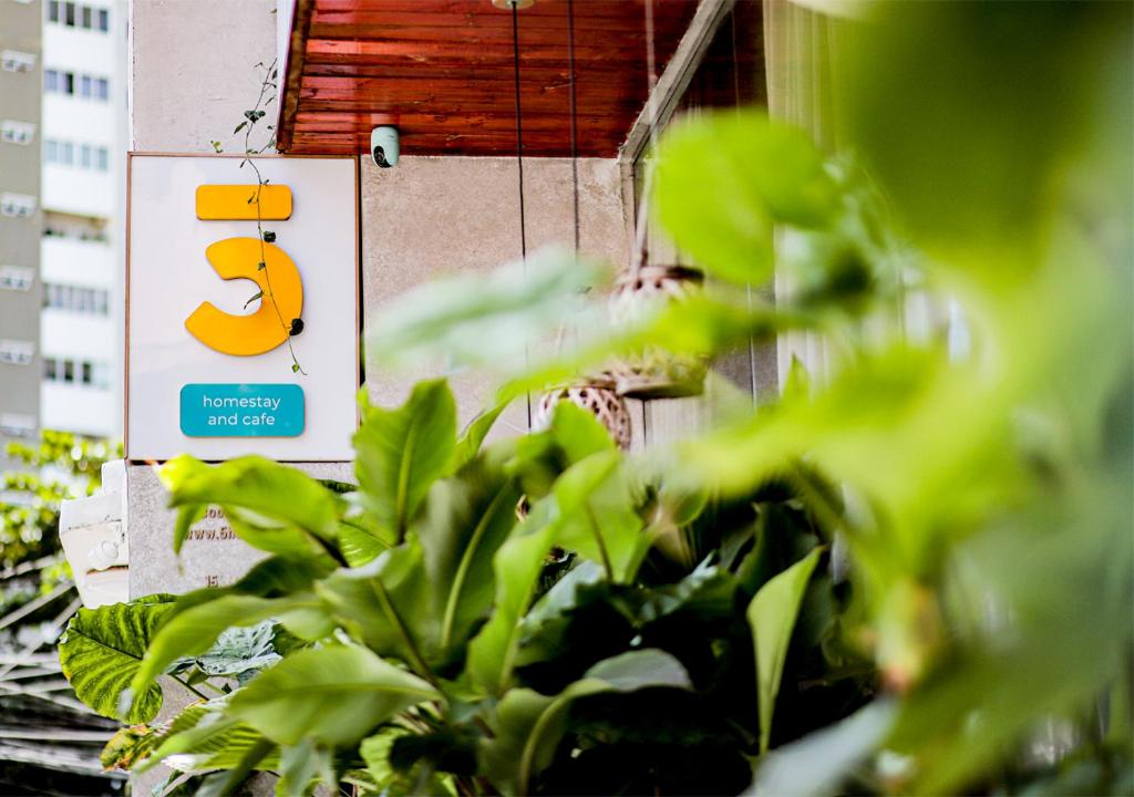 a sign on the side of a building with plants at 5-homestay I in Vung Tau