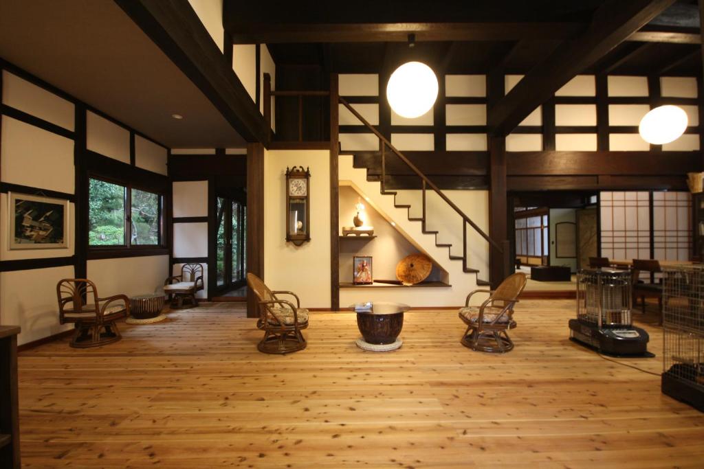 Habitación grande con suelo de madera y escaleras. en 農家民宿 山いちご, en Echizen