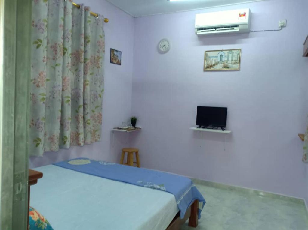 a small room with a bed and a tv at Inap Desa 2 in Baling