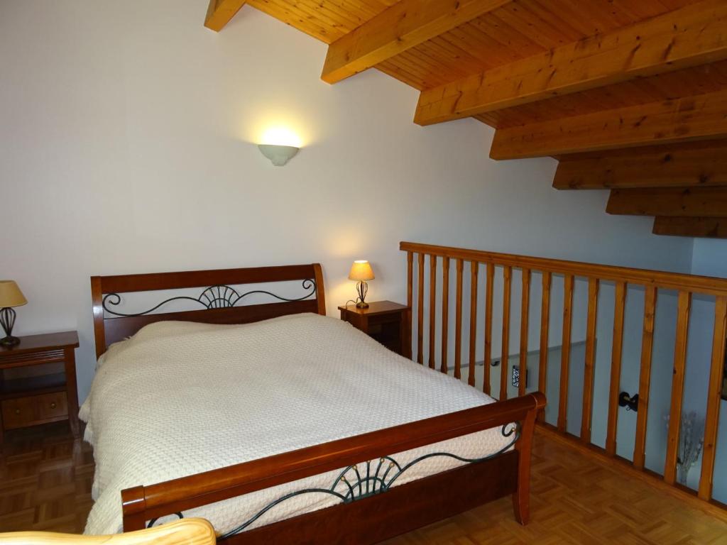 a bedroom with a bed and a wooden staircase at Maison Les Sables-d&#39;Olonne, 4 pièces, 6 personnes - FR-1-92-798 in Les Sables-d&#39;Olonne