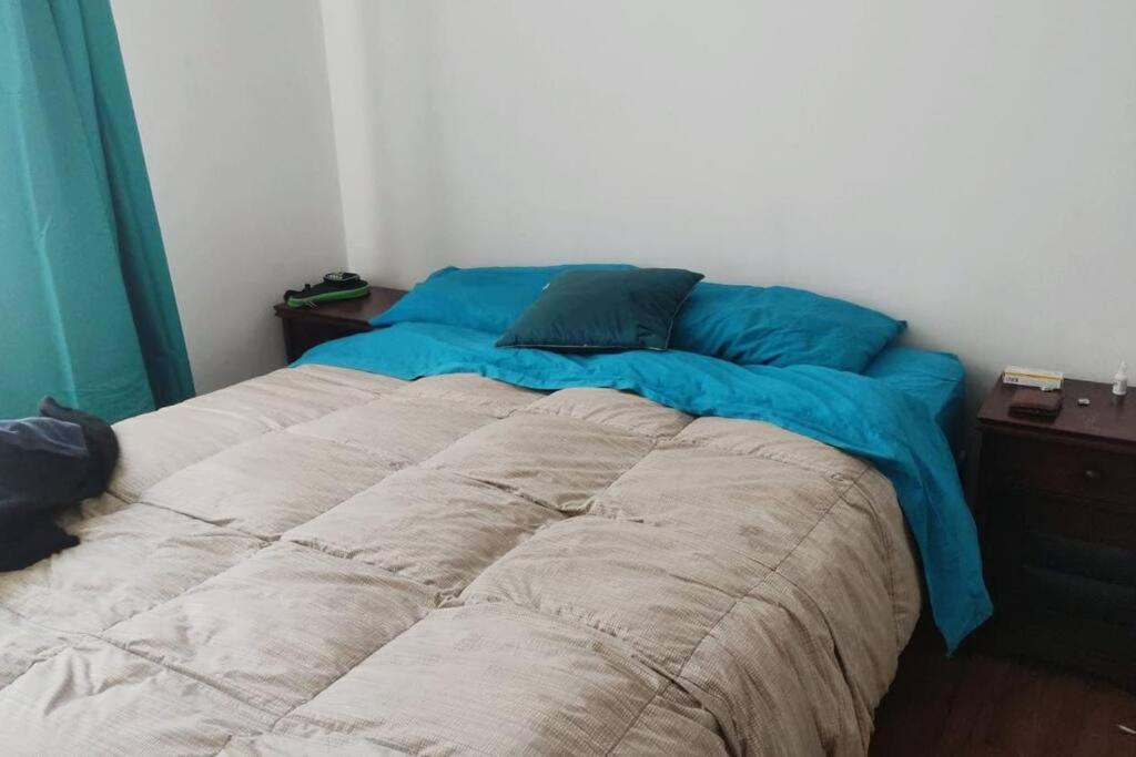 a bed with blue sheets in a bedroom at Valparaiso Rental in Valparaíso