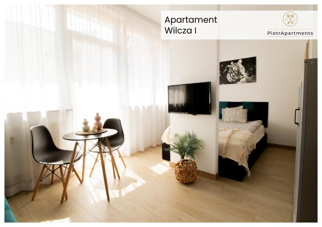 PiotrApartments Luxury Apartments in City Centre في وارسو: غرفة نوم بسرير وطاولة وكراسي