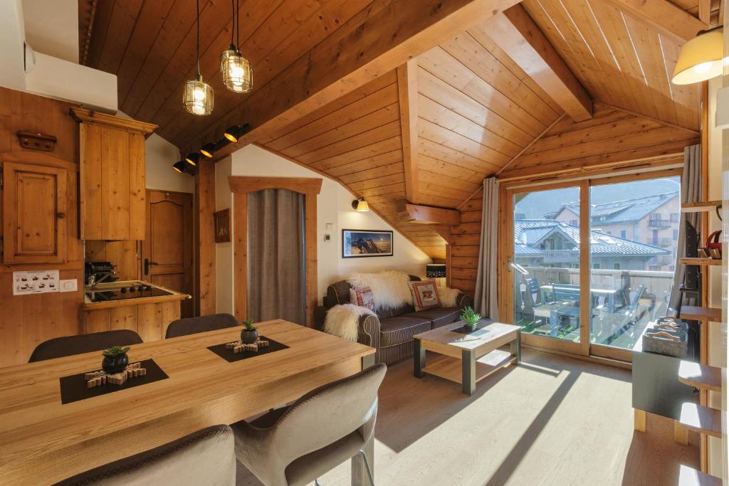 a kitchen and living room with a table and a couch at La Ginabelle - Sauna & Swimming pool - Happy Rentals in Chamonix-Mont-Blanc