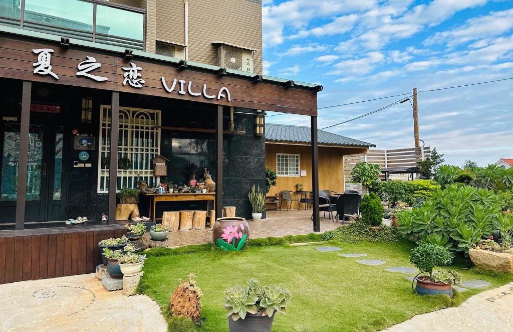 a restaurant with a lawn in front of a building at Summer Love Villa in Jinning