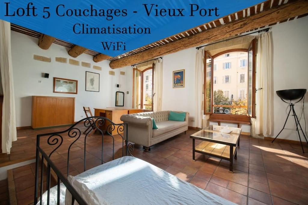 een woonkamer met een bank en een tafel bij Air-conditioned loft in the heart of the old port in Marseille