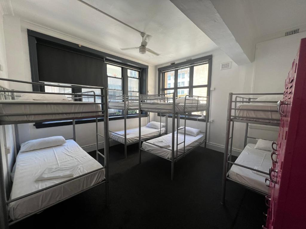 um quarto com 4 beliches num edifício em The Downing Hostel em Sidney