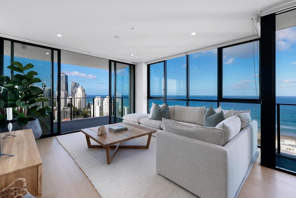 a living room with a white couch and large windows at Opus Broadbeach in Gold Coast