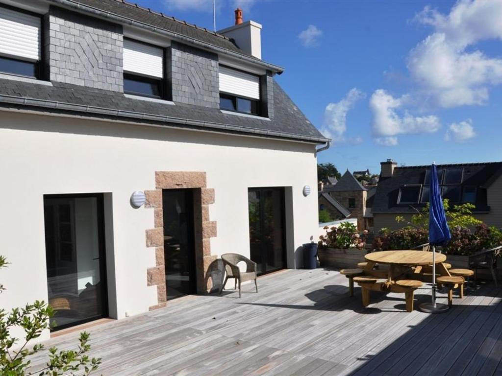 une terrasse en bois avec une table et un banc dans l'établissement Belle maison 3* à 600m de la plage à Trégastel - FR-1-368-195, à Trégastel