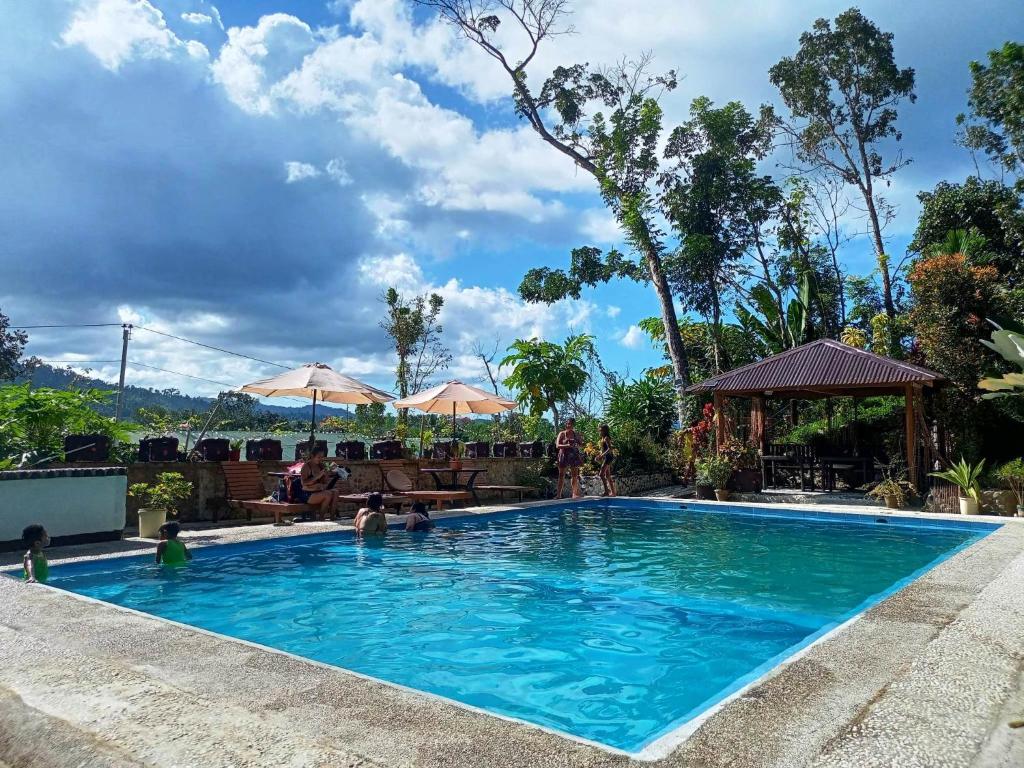 uma piscina num resort com pessoas em Dheltor Hilltop em San Vicente