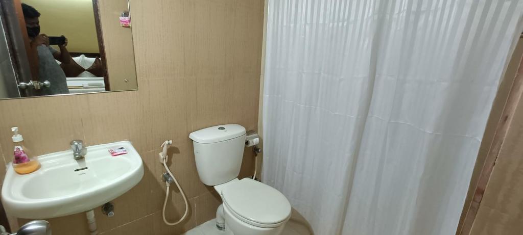 a bathroom with a white toilet and a sink at Bulande Comforts-Service Apartment ITPL Whitefield in Bangalore