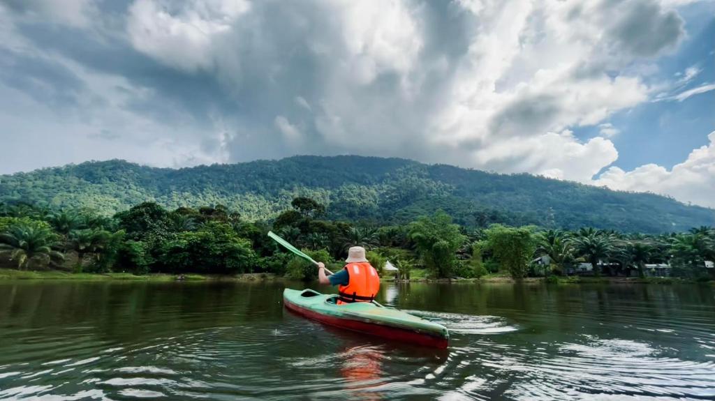 un hombre está en un kayak en un río en Sahom Valley Resort - Agro & Eco Park, en Kampar