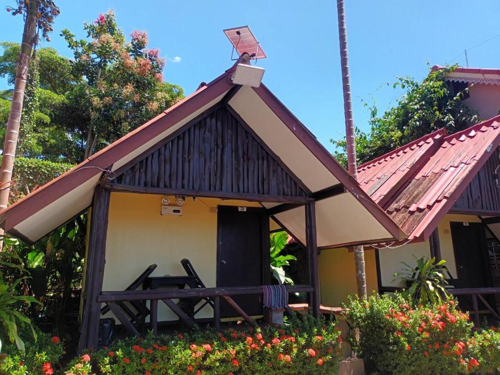 een huisje met een rood dak en een veranda bij SSP Bungalow in Trat