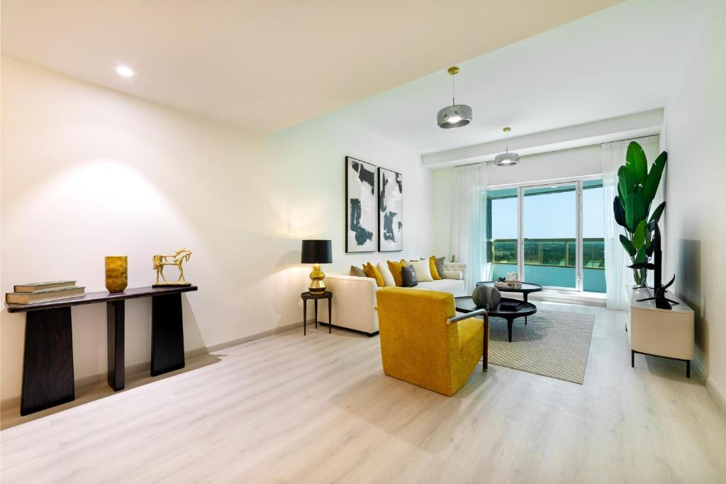 ein Wohnzimmer mit einem gelben Stuhl und einer Couch in der Unterkunft Maison Privee - Millennium Executive Tower in Dubai