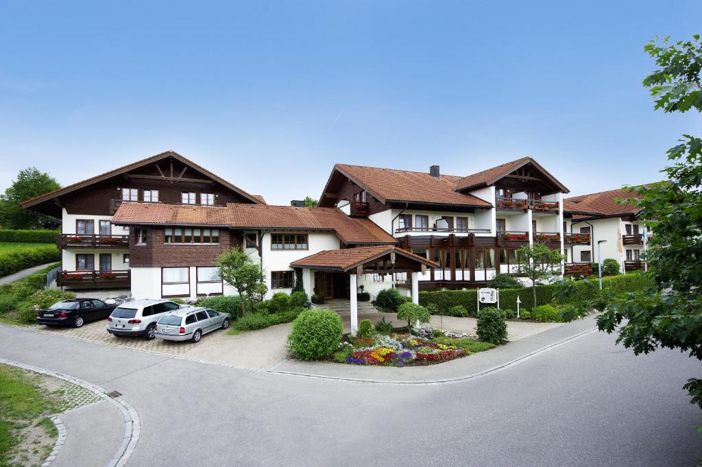 una grande casa con macchine parcheggiate di fronte di Concordia Vitalhotel & SPA a Oberstaufen