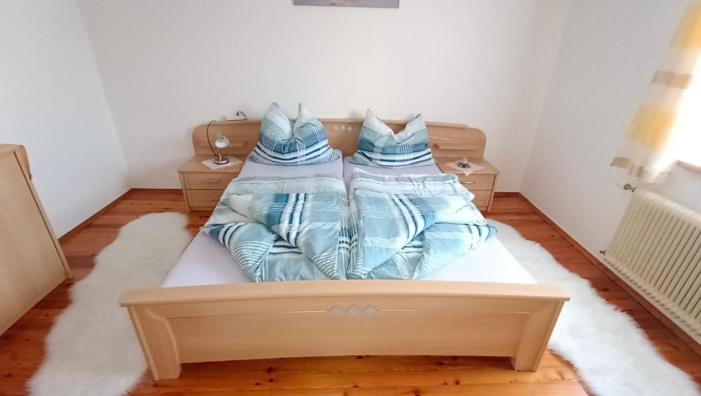 a bedroom with a bed with blue pillows on it at Apartment Monsberger in Wolfsberg