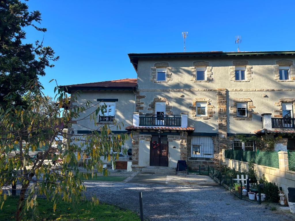 un gran edificio de piedra con puerta y balcón en Lekuona, en Galdakao