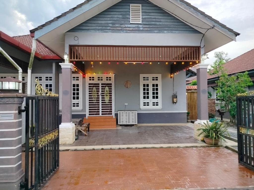 una casa con un porche con una valla en Rumah Tamu Firdaus, en Marang