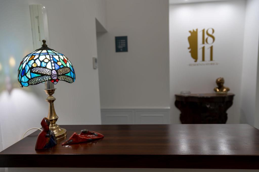 uma lâmpada sobre uma mesa com uma lâmpada de borboleta de vitral em 1811 Residenza Storica em Nápoles