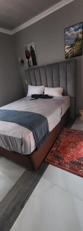 Schlafzimmer mit einem großen Bett mit Kopfteil in der Unterkunft New apollo lodge in Roodepoort