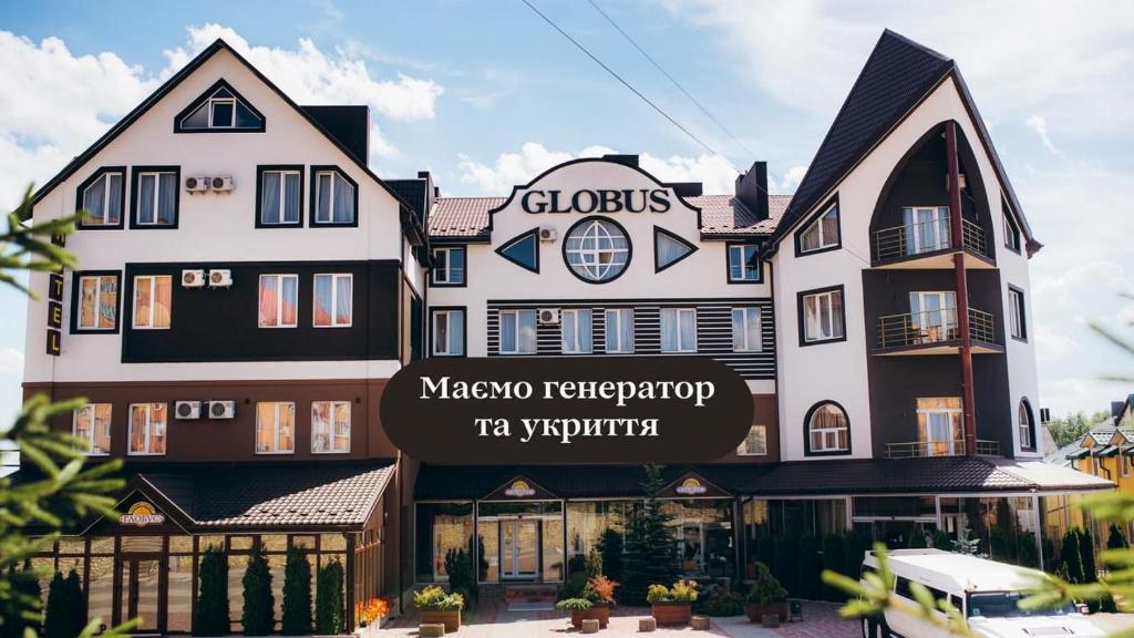 een groot gebouw met een bord ervoor bij Globus Hotel in Ternopilʼ