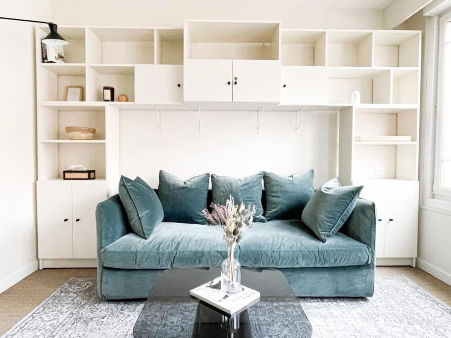 ein Wohnzimmer mit einem blauen Sofa und einem Tisch in der Unterkunft Appartement calme centre ville rénovation récente in Le Touquet-Paris-Plage