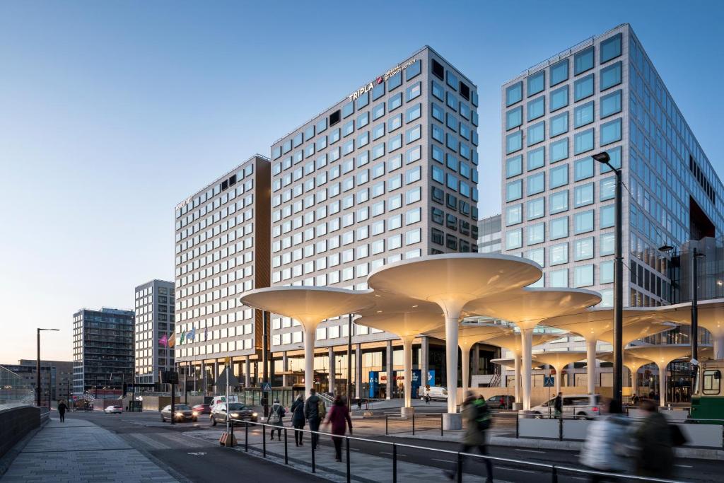 people walking on a street in front of a building at Original Sokos Hotel Tripla Helsinki in Helsinki