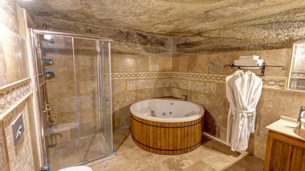 a bathroom with a large tub and a shower at Chelebi Cave Suites Over 6 Years Old in Göreme