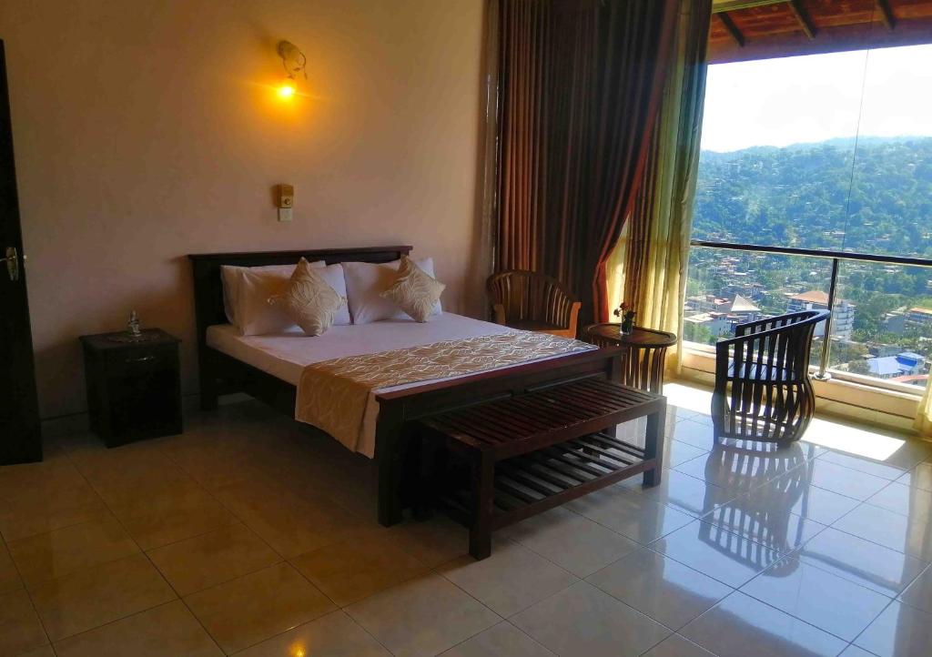 a bedroom with a bed and a chair and a window at Sky Valley in Kandy