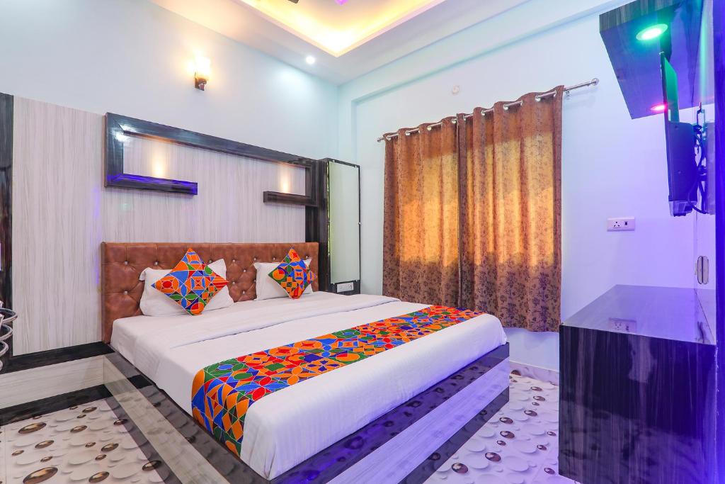 a bedroom with a large bed with colorful pillows at FabHotel Lumbini International in Varanasi